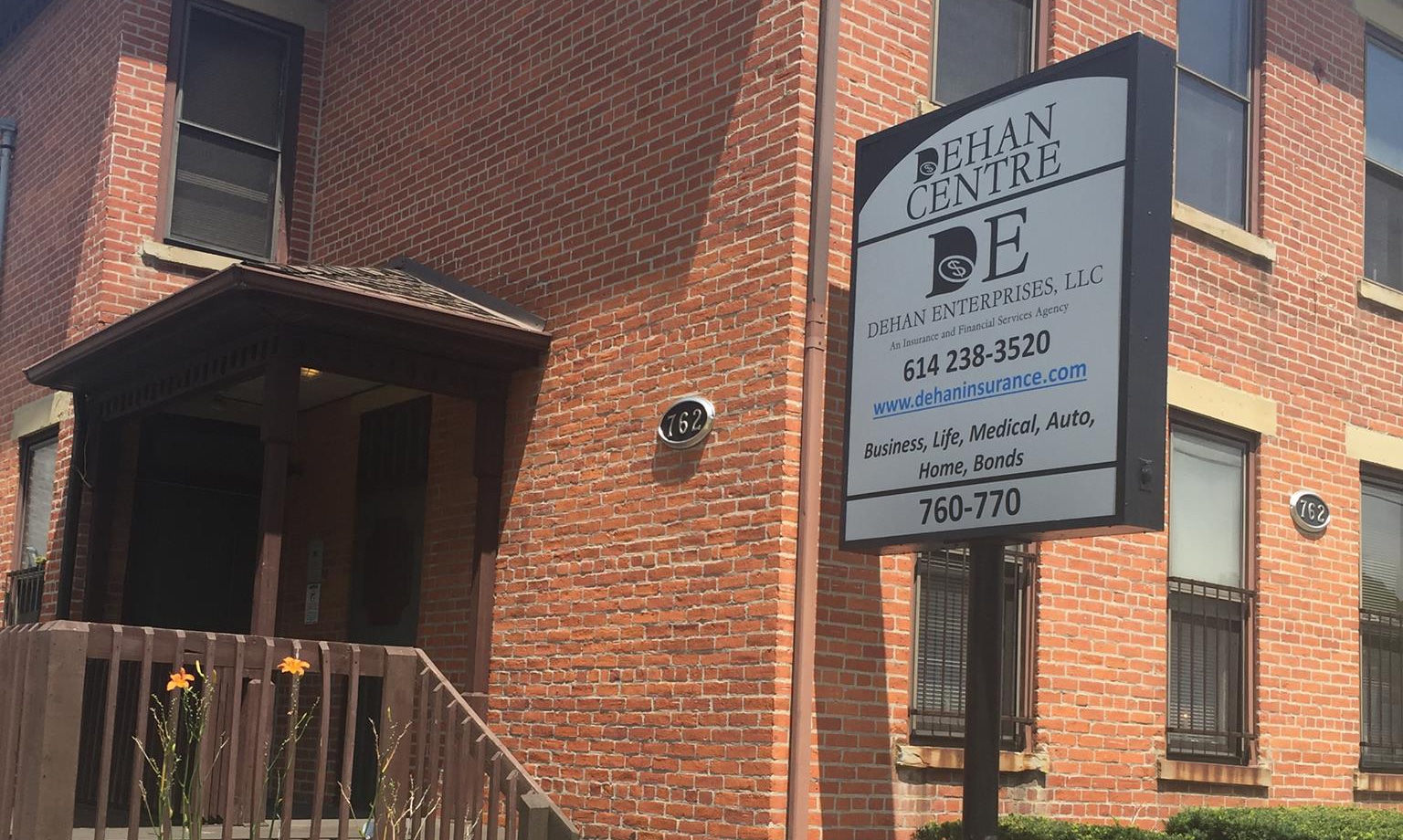 A brick building with a sign in front of it.